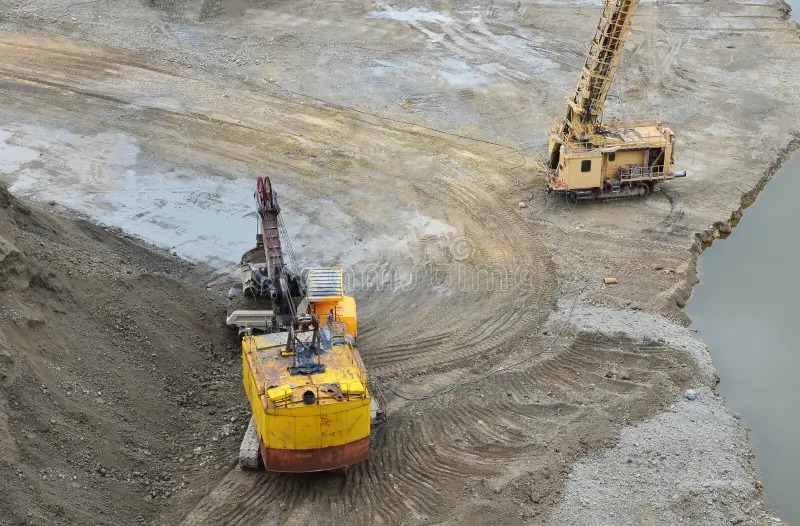 Vista aérea de excavadora y perforadora en faena minera